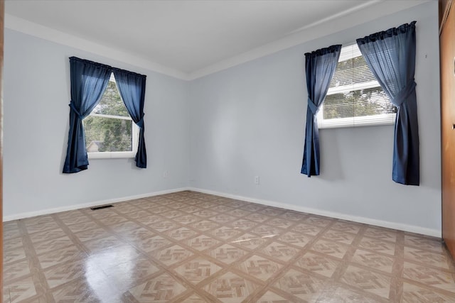 spare room with crown molding and parquet floors