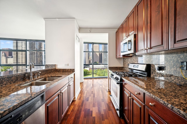 kitchen with tasteful backsplash, sink, crown molding, appliances with stainless steel finishes, and dark hardwood / wood-style flooring