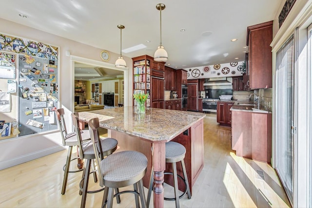 611 Elmwood Ave, Wilmette, IL 60091 - kitchen with dark brown cabinets, light wood-style floors, premium appliances, light stone countertops, and plenty of natural light