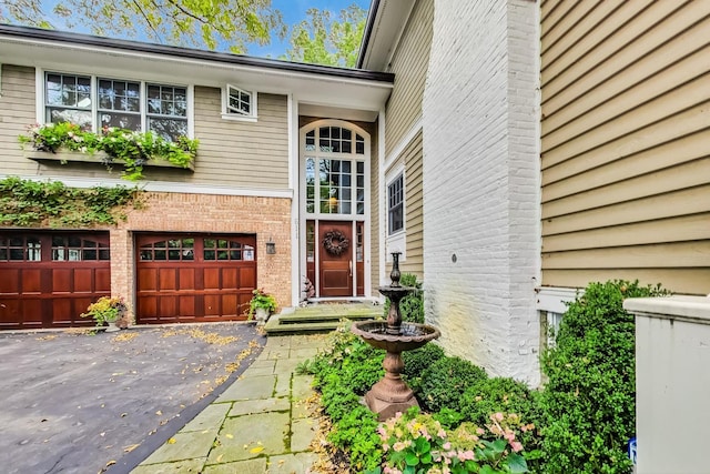 611 Elmwood Ave, Wilmette, IL 60091 - property entrance with an attached garage, driveway, and brick siding