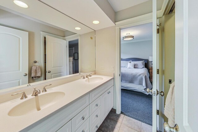 ensuite bathroom with double vanity, a sink, tile patterned flooring, and ensuite bath