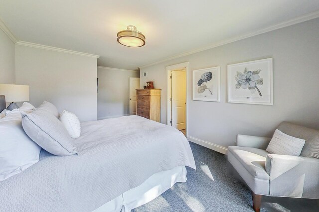 bedroom with dark colored carpet, ornamental molding, and baseboards