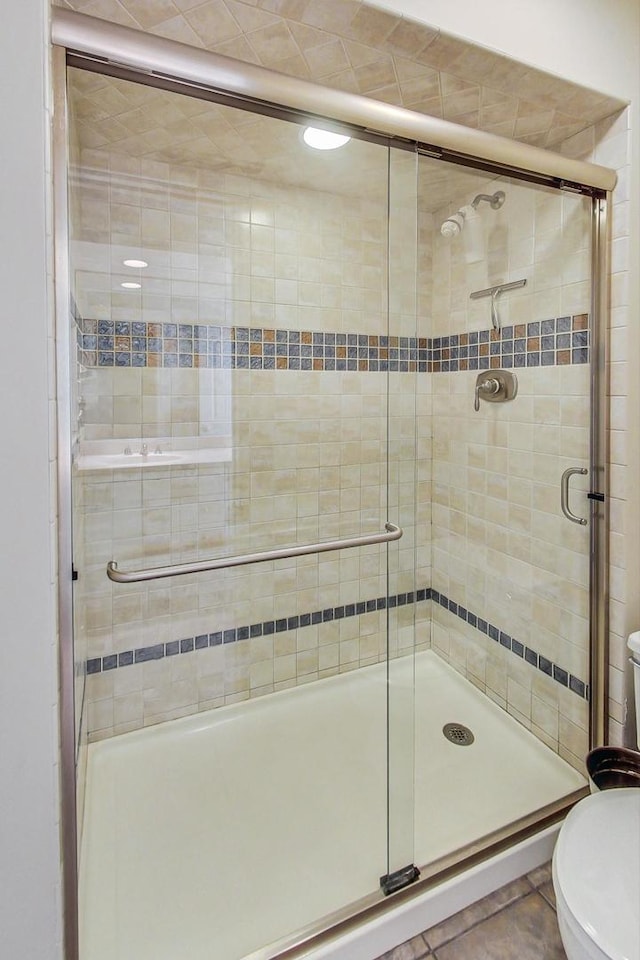 full bathroom featuring toilet and a shower stall