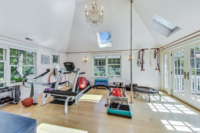 exercise area featuring visible vents, high vaulted ceiling, a healthy amount of sunlight, and a skylight