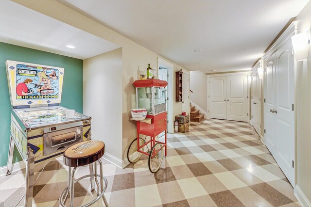 interior space featuring baseboards, recessed lighting, light floors, and stairway