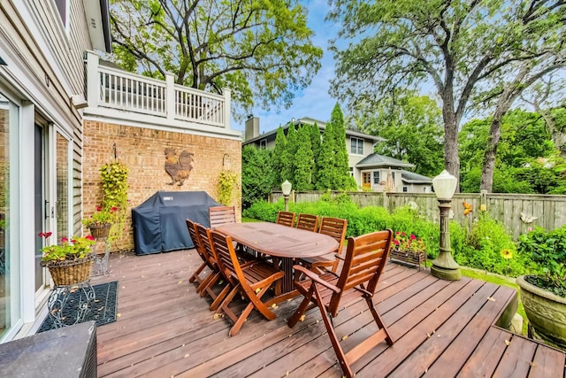 wooden deck featuring outdoor dining area, a fenced backyard, and area for grilling