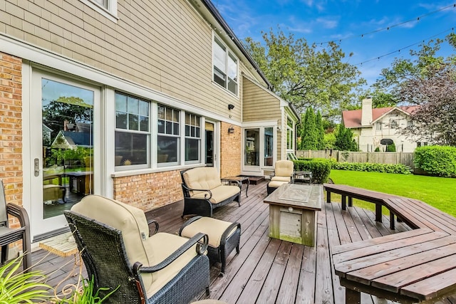 deck with a yard, fence, and an outdoor living space with a fire pit