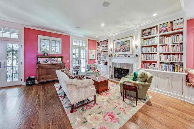 611 Elmwood Ave, Wilmette, IL 60091 - living room featuring french doors, crown molding, wood finished floors, built in features, and a brick fireplace