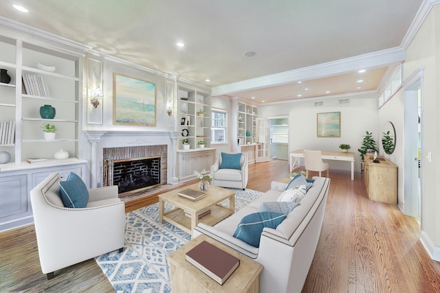living area featuring a fireplace, baseboards, ornamental molding, and light wood-style floors