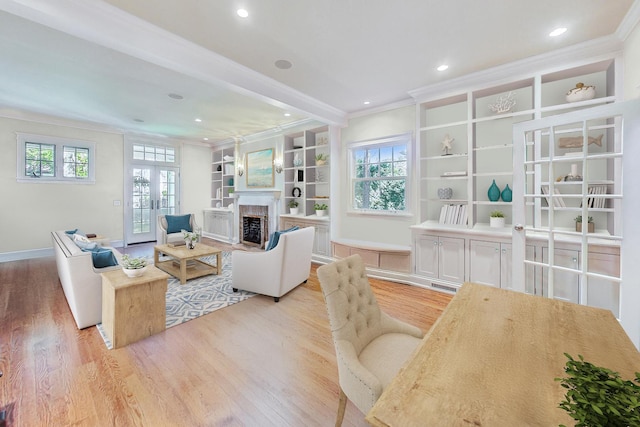 living room with ornamental molding, light wood finished floors, and a fireplace