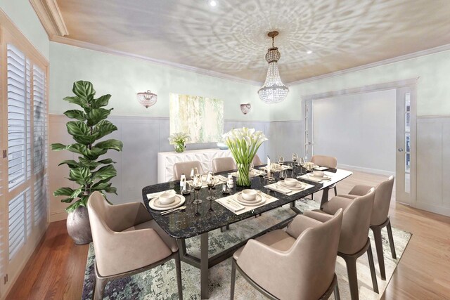 dining area featuring an inviting chandelier, ornamental molding, light wood finished floors, and wainscoting