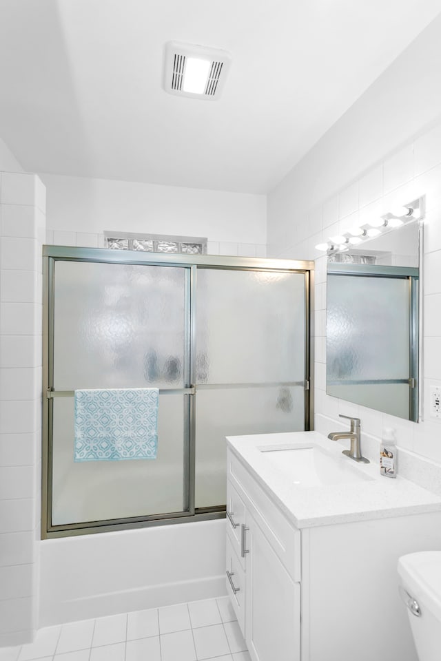 full bathroom with vanity, enclosed tub / shower combo, toilet, and tile patterned flooring