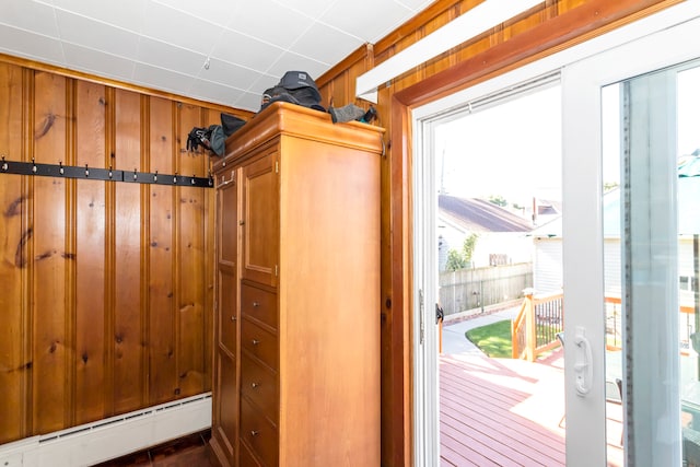 doorway featuring wood walls and a baseboard radiator