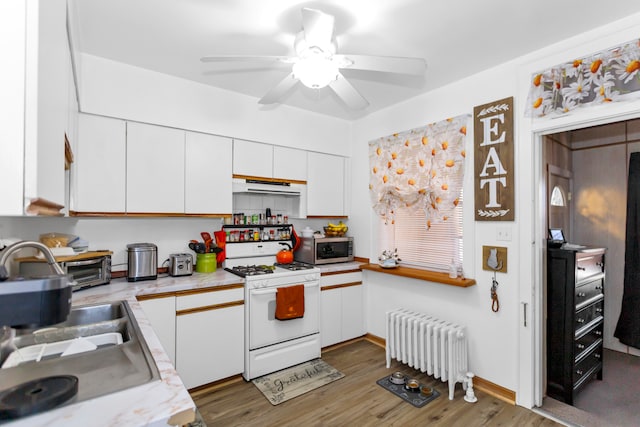 kitchen featuring radiator, white cabinets, wood-type flooring, and gas range gas stove