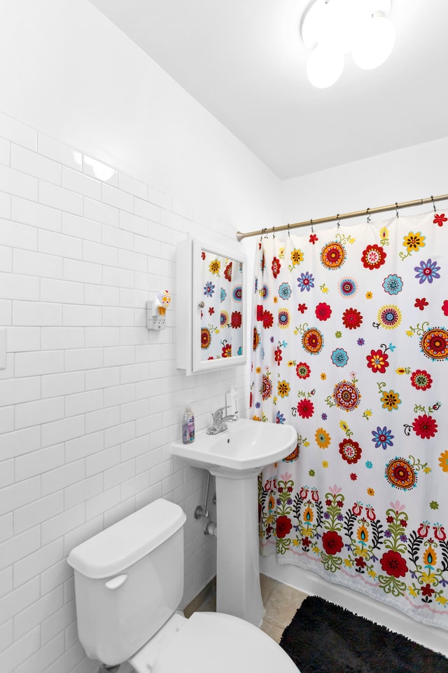 bathroom featuring toilet, tile walls, and a shower with shower curtain