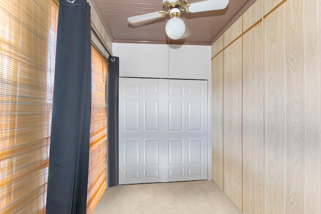 garage featuring ceiling fan and wooden walls