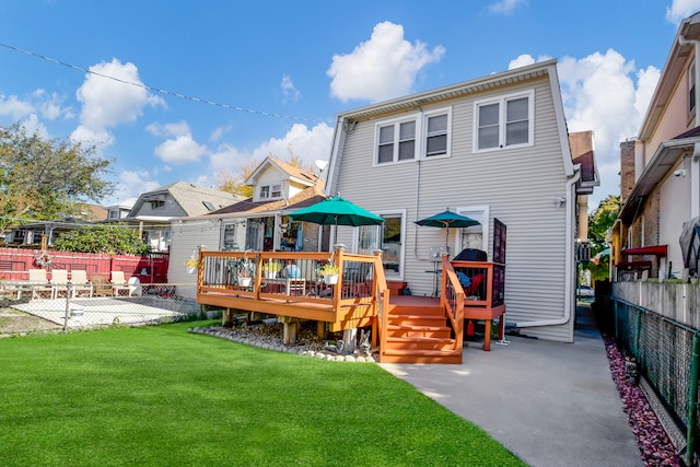 rear view of property with a wooden deck, a patio, and a yard