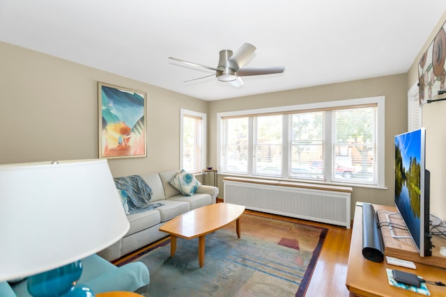 living room with radiator, ceiling fan, and hardwood / wood-style floors