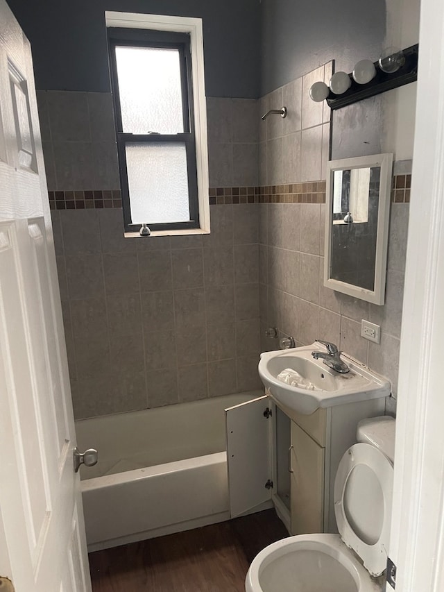 full bathroom with tiled shower / bath combo, vanity, toilet, and wood-type flooring