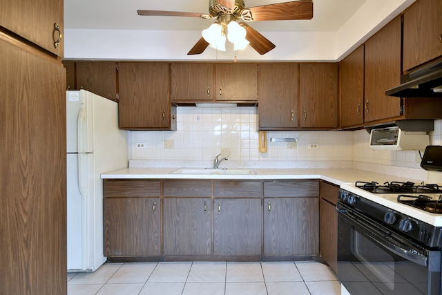 kitchen with sink, decorative backsplash, white appliances, light tile patterned floors, and ceiling fan