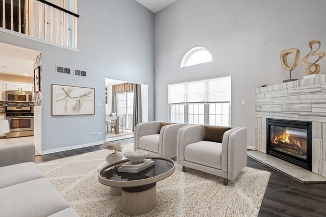 living room featuring dark wood-type flooring and a high ceiling