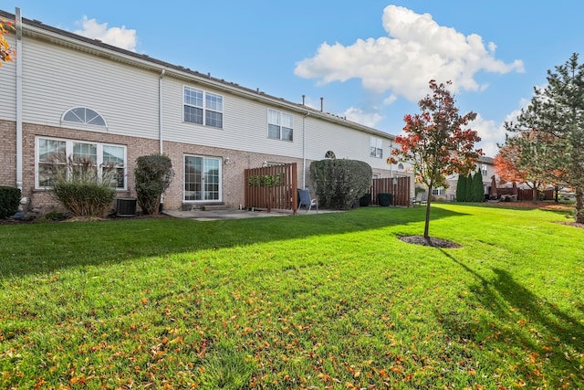 rear view of house with a yard and central AC unit