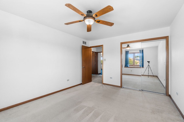 unfurnished bedroom featuring light carpet, ceiling fan, and a closet