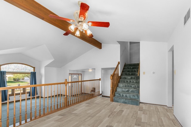 interior space featuring wood-type flooring, lofted ceiling with beams, and ceiling fan