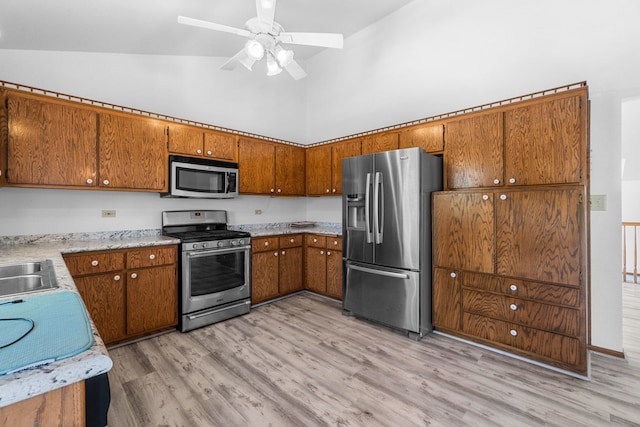 kitchen featuring light hardwood / wood-style floors, ceiling fan, stainless steel appliances, and high vaulted ceiling