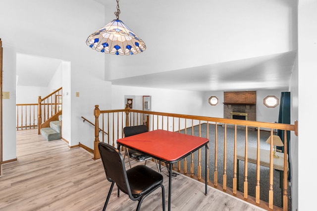 dining area with wood-type flooring and a large fireplace