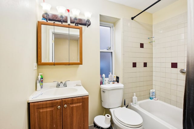 full bathroom with tiled shower / bath, vanity, and toilet