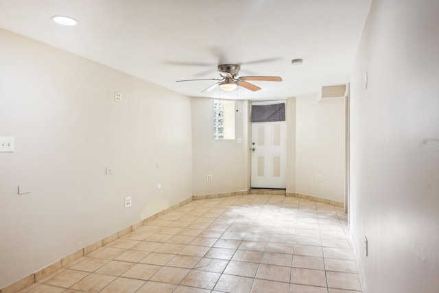 tiled empty room featuring ceiling fan