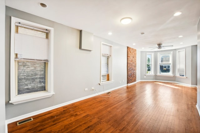 unfurnished living room featuring wood-type flooring and ceiling fan