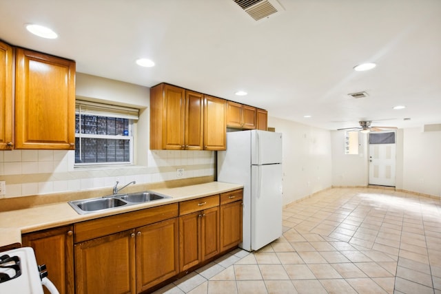 kitchen with white appliances, ceiling fan, tasteful backsplash, and sink