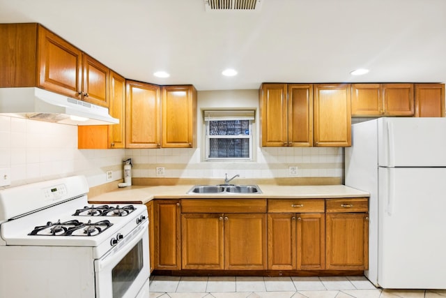 kitchen with white appliances, tasteful backsplash, light tile patterned floors, and sink