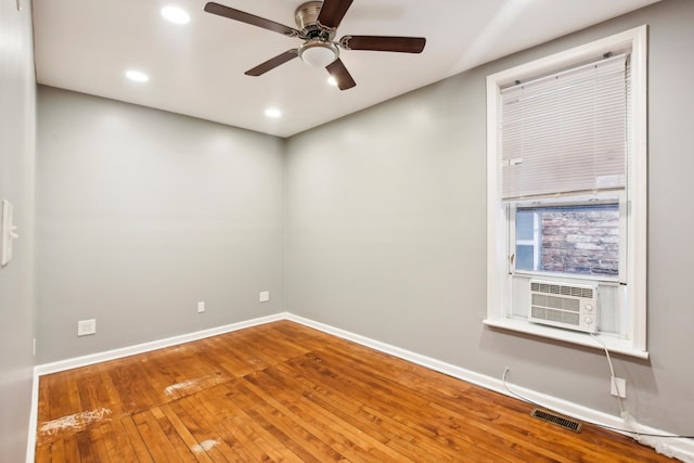 spare room with ceiling fan, cooling unit, and wood-type flooring