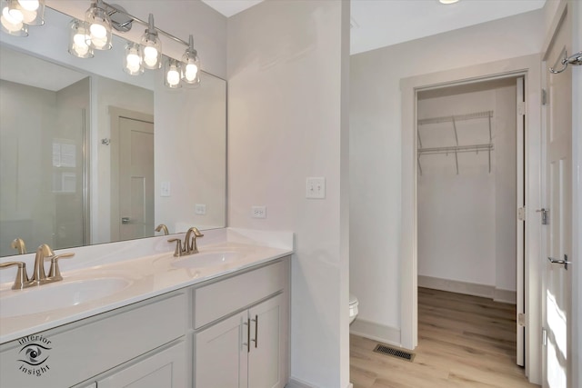 bathroom with a shower, vanity, toilet, and wood-type flooring