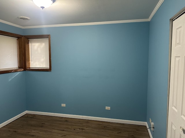 spare room with baseboards, ornamental molding, and dark wood-style flooring