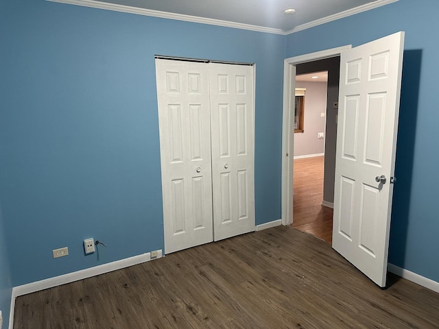unfurnished bedroom with crown molding, baseboards, and dark wood-style floors