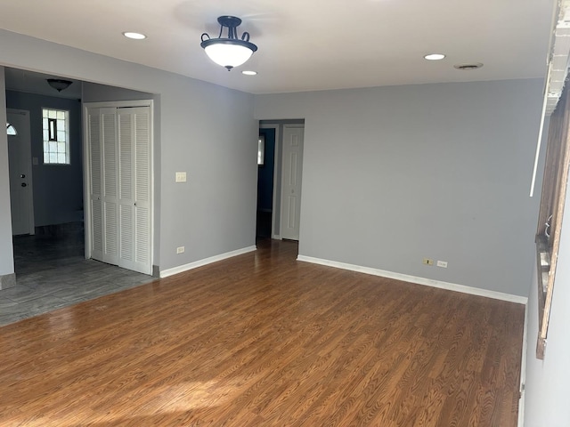 unfurnished room with baseboards, wood finished floors, and recessed lighting