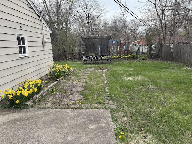 view of yard featuring fence and a trampoline