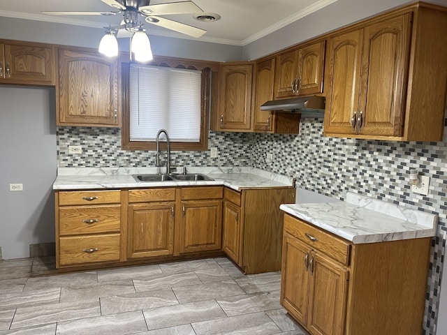 kitchen featuring ornamental molding, sink, ceiling fan, and tasteful backsplash