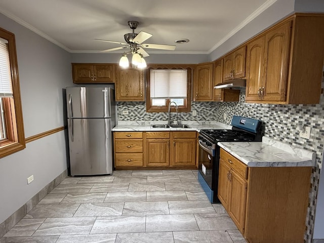 kitchen with a sink, visible vents, freestanding refrigerator, range with gas stovetop, and brown cabinets