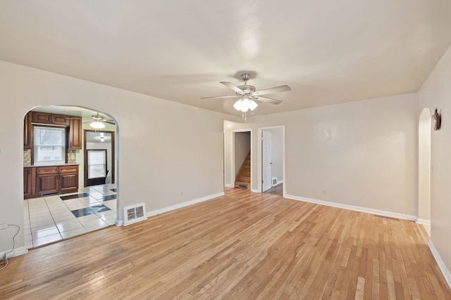 spare room with ceiling fan and light wood-type flooring