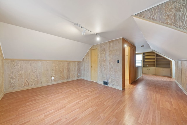 bonus room with lofted ceiling and light hardwood / wood-style flooring