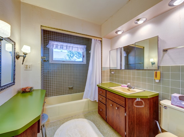 full bathroom with tile walls, shower / tub combo, vanity, and toilet