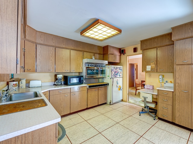 kitchen featuring white refrigerator, sink, and tasteful backsplash