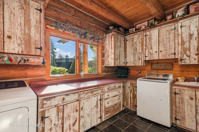 clothes washing area with dark tile patterned flooring, cabinets, wood ceiling, and washer and dryer