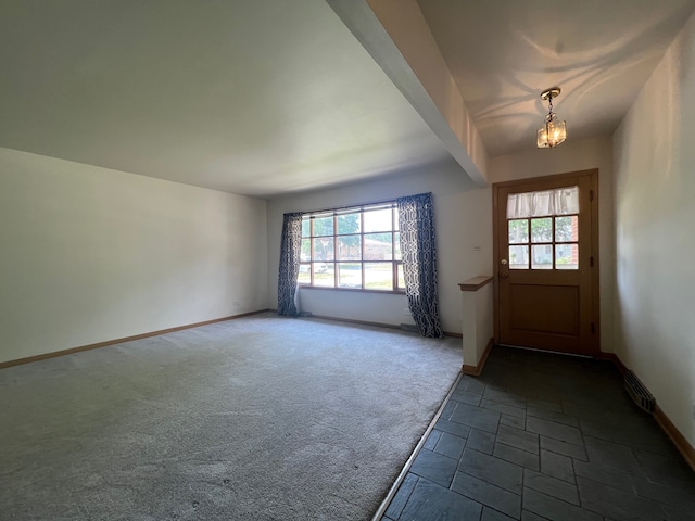 entrance foyer with an inviting chandelier, carpet flooring, and a wealth of natural light