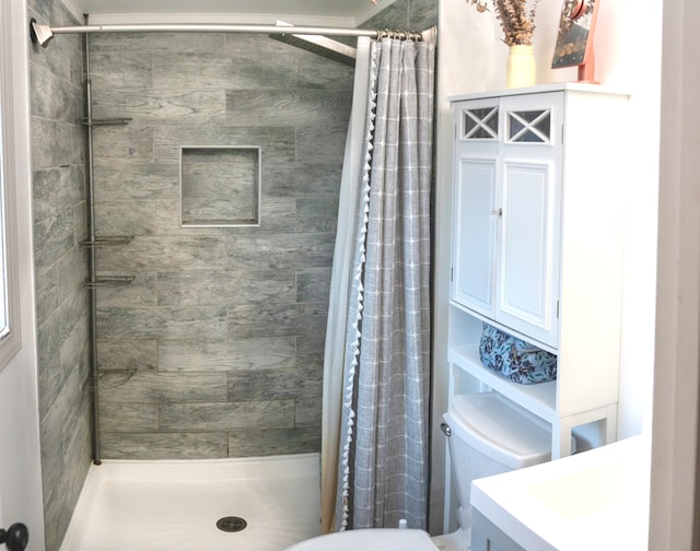 bathroom with a shower with shower curtain, vanity, and toilet